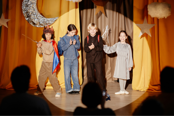 children on stage, in costume for acting class