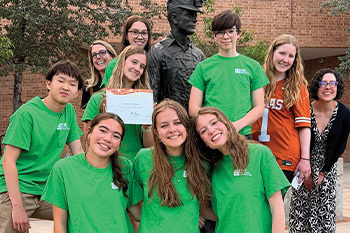 The Youth Advisory board posing with a statue 