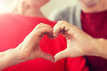 image of two people with hands forming a heart