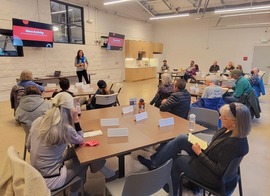 people sitting around a table watching a presentation