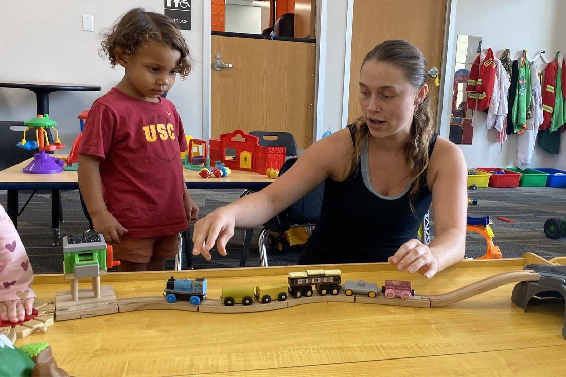 A child watch attendant playing with a kid