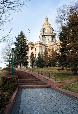 Image of Colorado State Capitol on steps approaching from the right side during sunny day