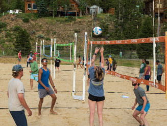 group of adults playing beach volleyball tournament