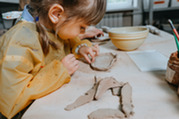 little girl making clay pot