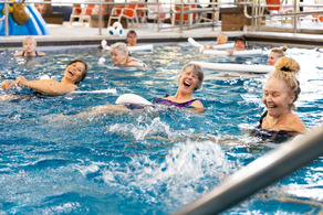 three women in the pool doing water aerobics