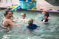 Suzanna Barth in pool teaching children's swim lessons