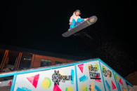 snowboarder in air above rail