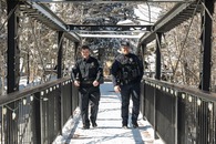 two silverthorne police officers walking across snowy bridge