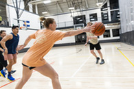 Group of women and men playing basketball