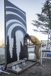 artist painting a mural board