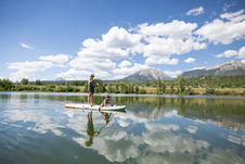 family paddleboarding on North Pond with mountains in background