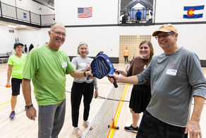group of adults playing pickleball