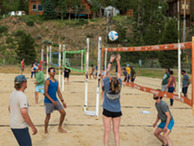adults playing sand volleyball