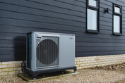 Air-source heat pump on the side of a residence