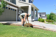 Woman removing sod from a yard.