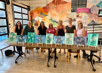 Eight women lined up and posing with their masterpieces