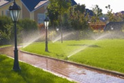 Sprinklers watering equal parts grass and sidewalk