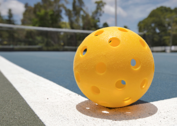 Closeup of pickleball ball on a pickleball court