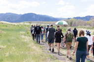 People going down a trail with the mountains in the background for the Historic Walk