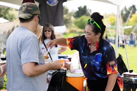 Person serving chili while dressed in chili attire during the Chili and Beer fest