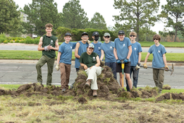 Boulder County Youth Corps posing on a throne made of sod 