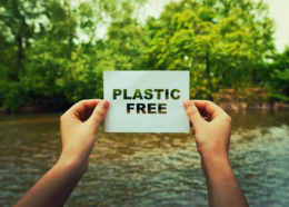 Hands holding a sign that says, "plastic free"