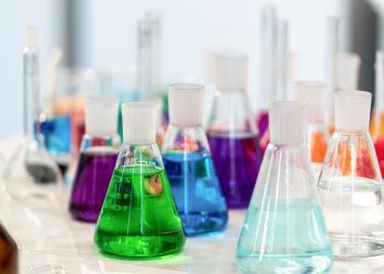 Colorful bubbling beakers sit on a lab table