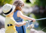 Two children holding a fishing pole