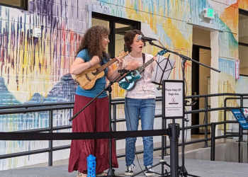 Two people sing and play ukuleles at Open Mic Night