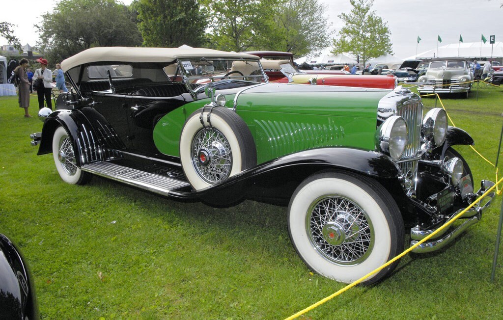 Historic Duesenberg in great condition siting on display in a field
