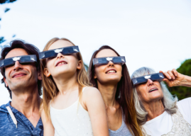 a family of four watches a solar eclipse