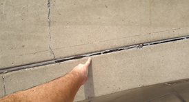 Person pointing at concrete joints that have been eroded and need repair