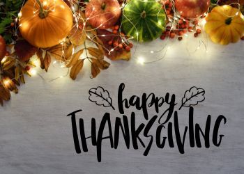 Happy Thanksgiving graphic with pumpkins and lights