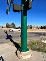 Newly painted green traffic light post