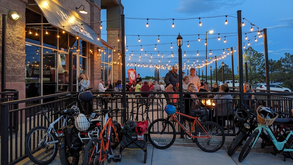 People gathered in the evening on a patio outside Bambi Brewing