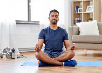 A person meditates on a yoga mat.
