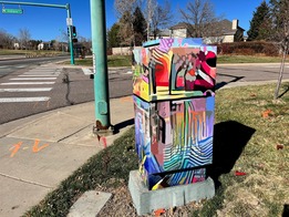 Colorful and abstract vinyl covers the large metal traffic equipment station on Rock Creek Parkway.