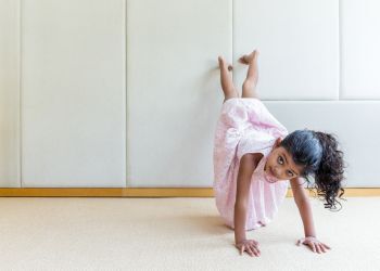 A young girl does a handstand
