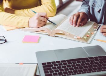 Two people studying with a book
