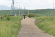 Person bike on the Boulder County Open Space trail with the flatirons lining the horizon on National Trails day 2023. 