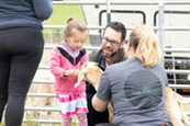 Child feeding a baby goat during National Trails Day 2023.