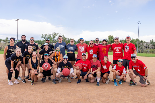 Two kickball teams posing together before the Championship game in 2023