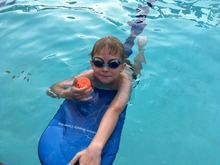 Child on a kickboard in the pool