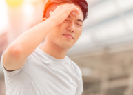 Person with hand on brow in the hot sun