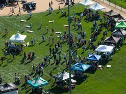 Aerial view of cornhole boards and vendor tents set up in Community Park