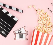 Popcorn and movie night tickets on pink background