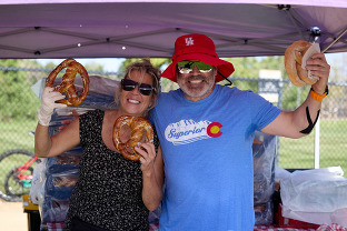 People holding up pretzels in their vendor booths during the 2023 Chili and Beer Fest.