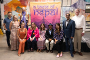 Attendees at 2023 A Taste of Nepal fundraiser pose with event banner