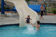 Child enjoying the slide into the South Pool. An adult is waiting to catch the child.