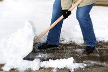Person shoveling snow from a sidewalk